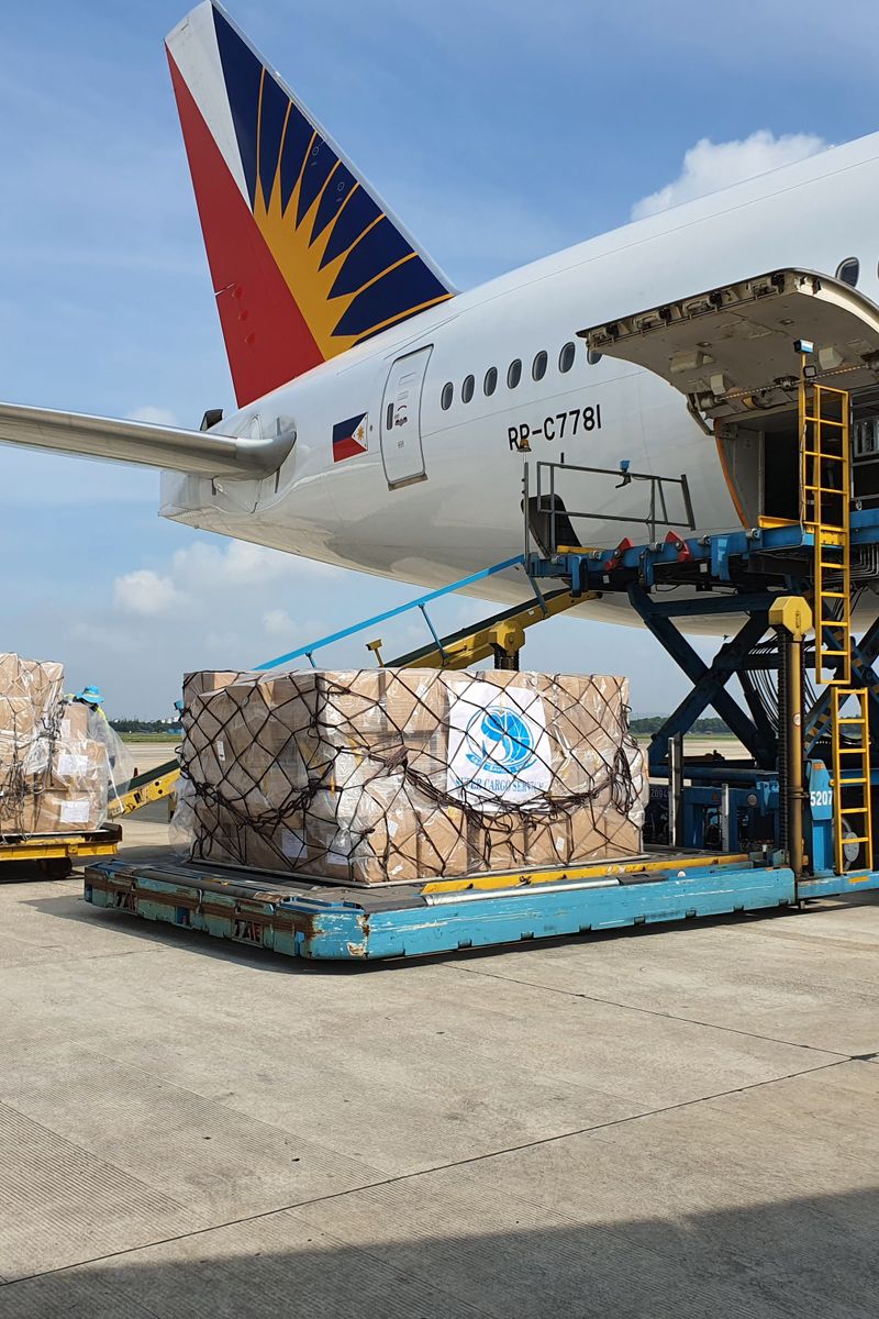 Cargo being loaded onto a commercial airplane at an airport in Ho Chi Minh City, Vietnam.
